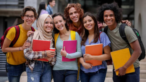Students posing in a row with books